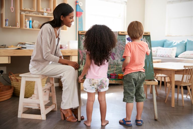 Teacher guiding two preschool students during hands-on learning activity
